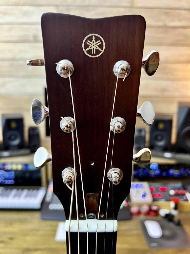 Acoustic guitar headstock cover removed.