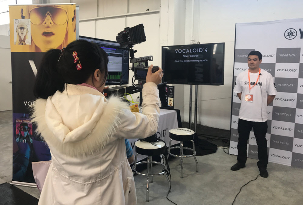 Young man posing for casual business picture with a female videographer in a photo studio.