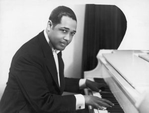 Man in tuxedo playing piano.