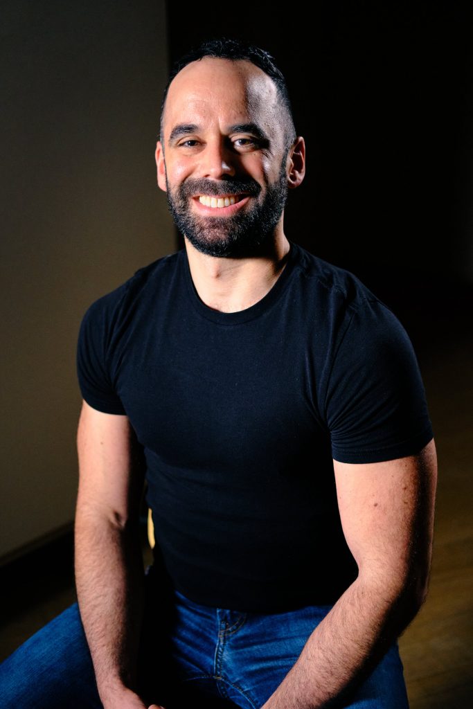 20220516-X-T4-DSCF7483-EDIT-Adam-Tendler-scaled Man in black t-shirt and jeans smiling for camera.