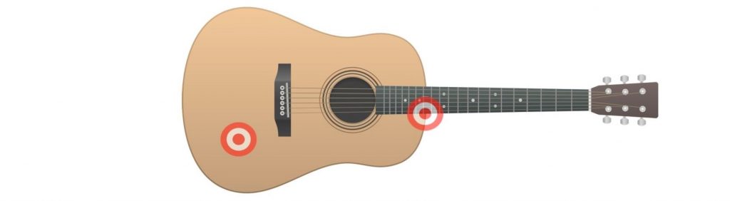 Spaced-pair-acoustic-guitar Acoustic guitar with two target emblems over certain locations.