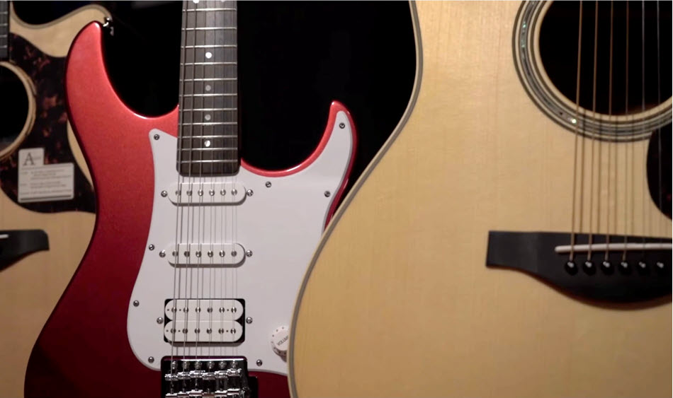 Closeup of guitars, both electric and acoustic.