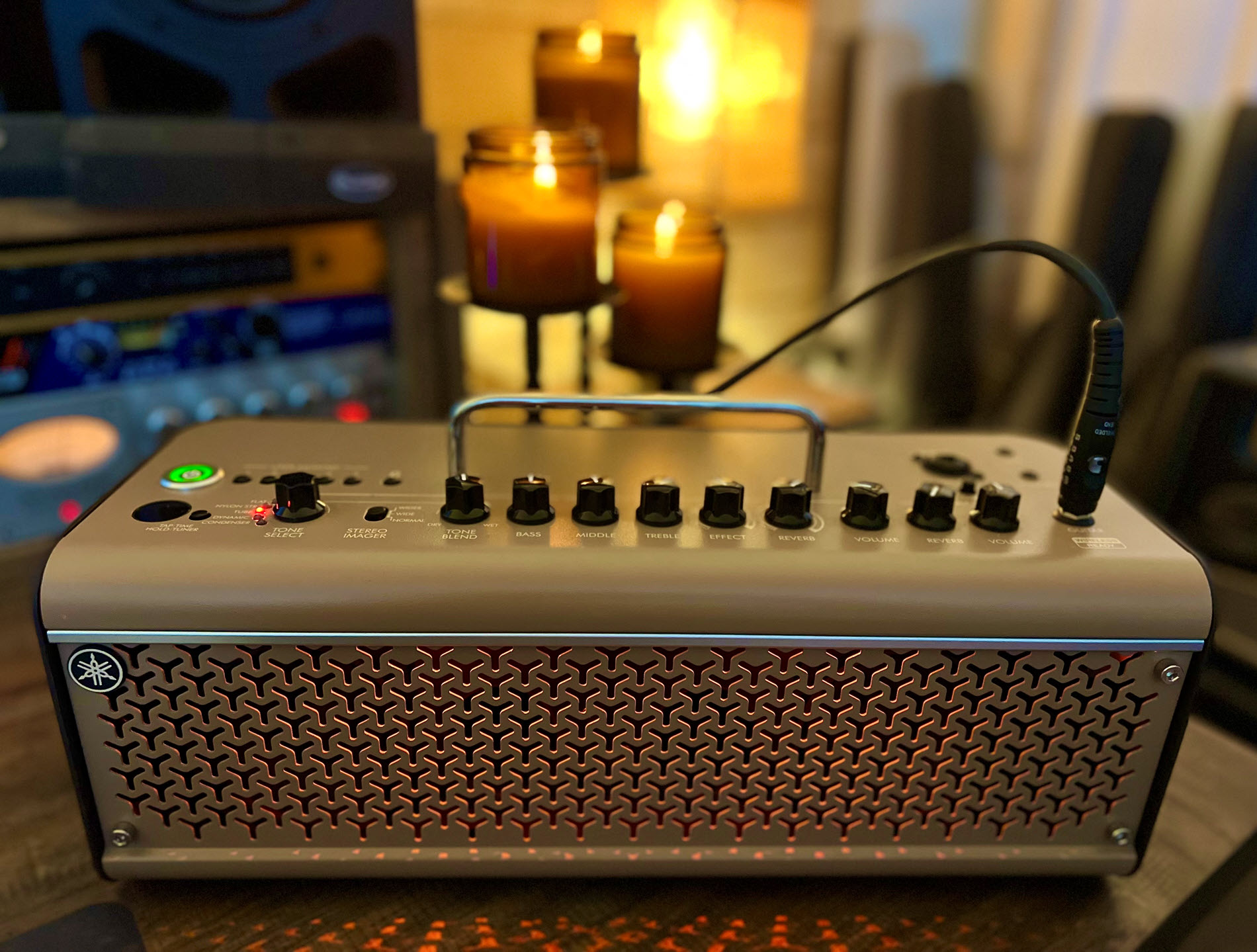 THR30IIA-resized Small guitar amp in foreground with fireplace and lit candles in background.