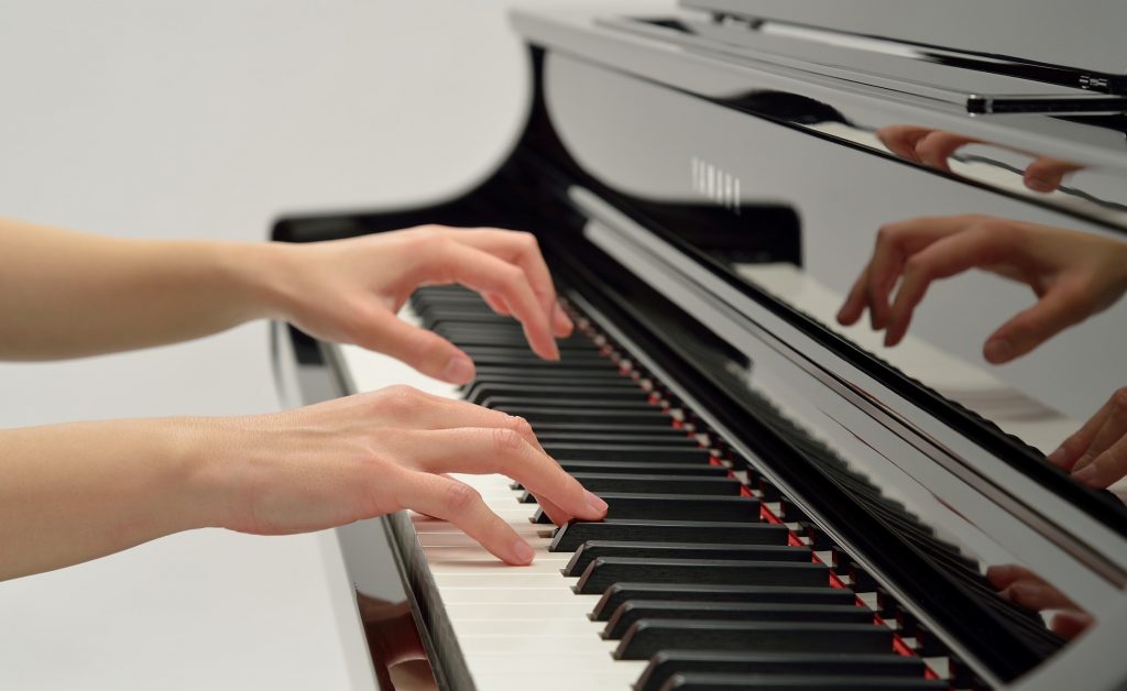 Closeup of someone's hands playing piano.