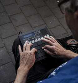 A man playing finger drums on the ground.