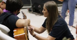 guitar teacher helping student
